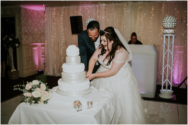 bride and groom cutting the wedding cake