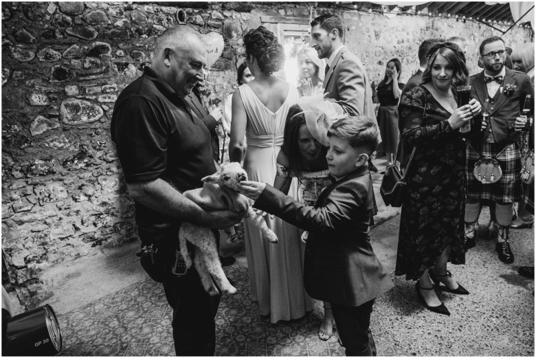 wedding guests at drinks reception in a rustic barn