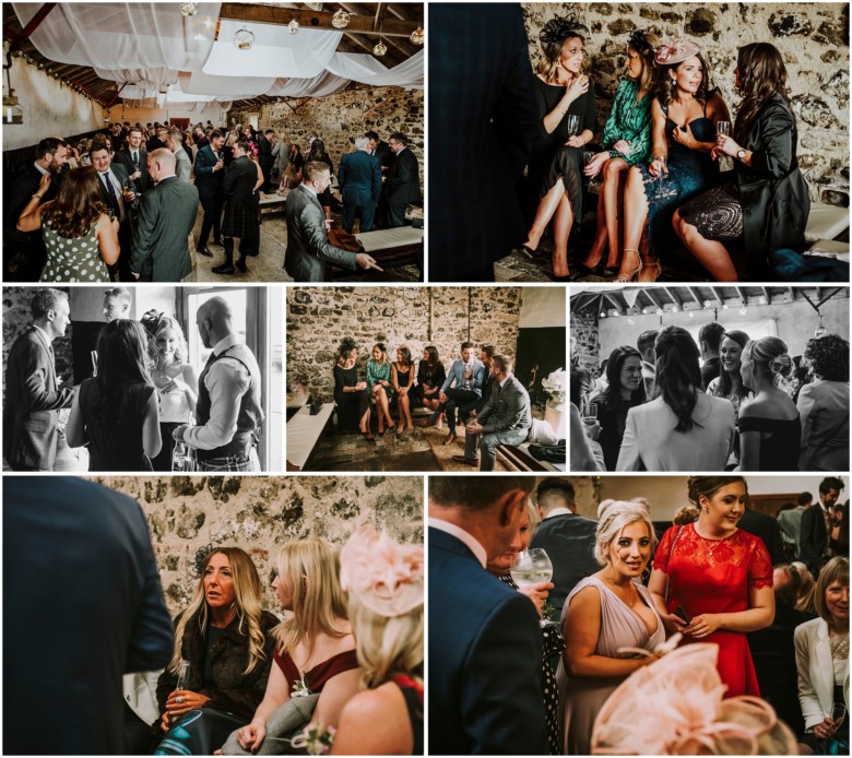 wedding guests at drinks reception in a rustic barn
