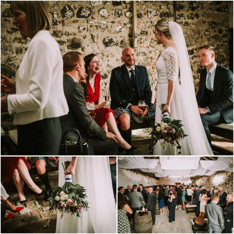 wedding guests at drinks reception in a rustic barn